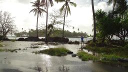 In this photo taken on March 9, 2016, a resident walks through tidal water in Majuro Atoll, in the Marshall Islands. Residents in low-lying areas of the Marshall Islands were braced for ongoing flooding on March 11, as a series of inundations underscored the Pacific island nation's vulnerability to climate change. / AFP / HILARY HOSIA        (Photo credit should read HILARY HOSIA/AFP/Getty Images)