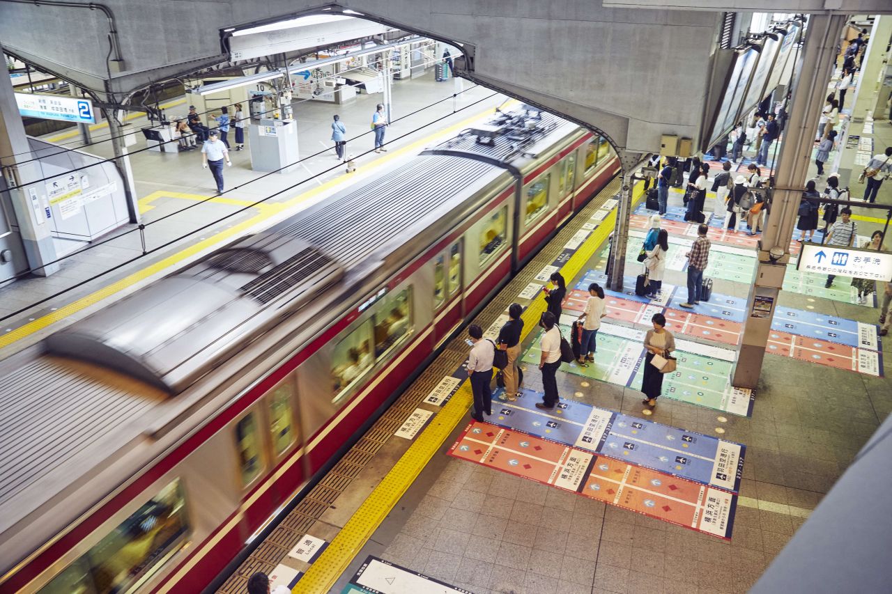 Commuters line up on color coded platforms at Shinagawa station, Tokyo. 
