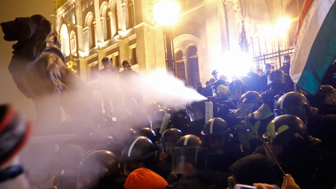 Riot police spray tear gas at demonstrators outside parliament on Thursday night. 