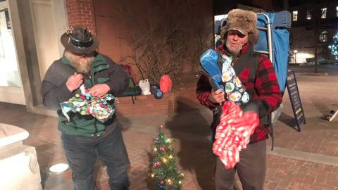 Two homeless men open presents they received from Rodney Smith Jr.