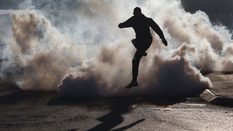 A protester jumps over smoke from burning tires during clashes with Israeli soldiers near the Hawara checkpoint, south of Nablus, on Friday.
