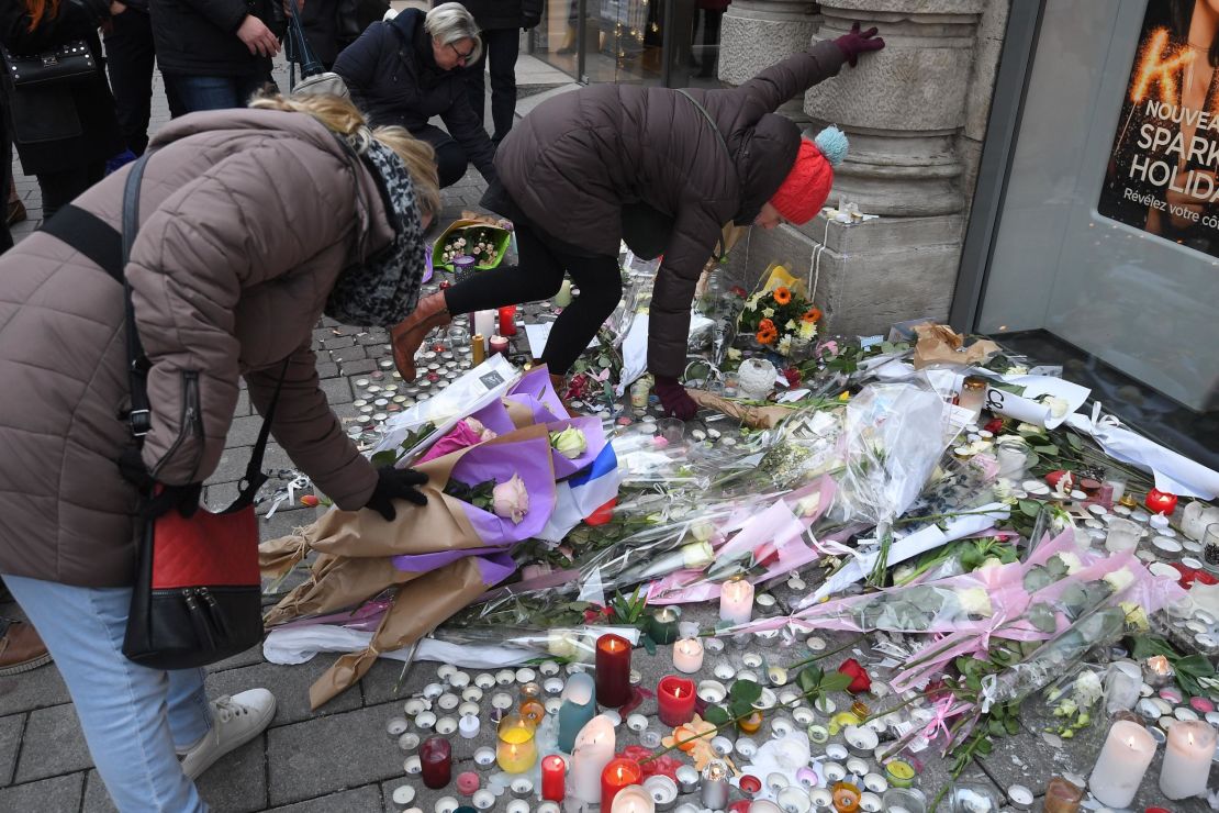 People lay flowers in tribute to the victims of Cherif Chekatt, on December 14, 2018 at Strasbourg's Christmas market, one day after after French police shot him dead. 