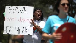 MIAMI, FL - AUGUST 03: Trenise Bryant joins others for a protest in front of the office of Rep. Carlos Curbelo (R-FL) on August 3, 2017 in Miami, Florida. The protesters are asking for Rep. Curbelo to explain his vote on the Affordable Care Act and to take a stand against what they say is 'President Donald Trump's budget that slashes Medicaid by more than $800 billion and weakens the social safety net for more than 113,000 residents in Rep. Curbelo's district who rely on Medicaid. '  (Photo by Joe Raedle/Getty Images)
