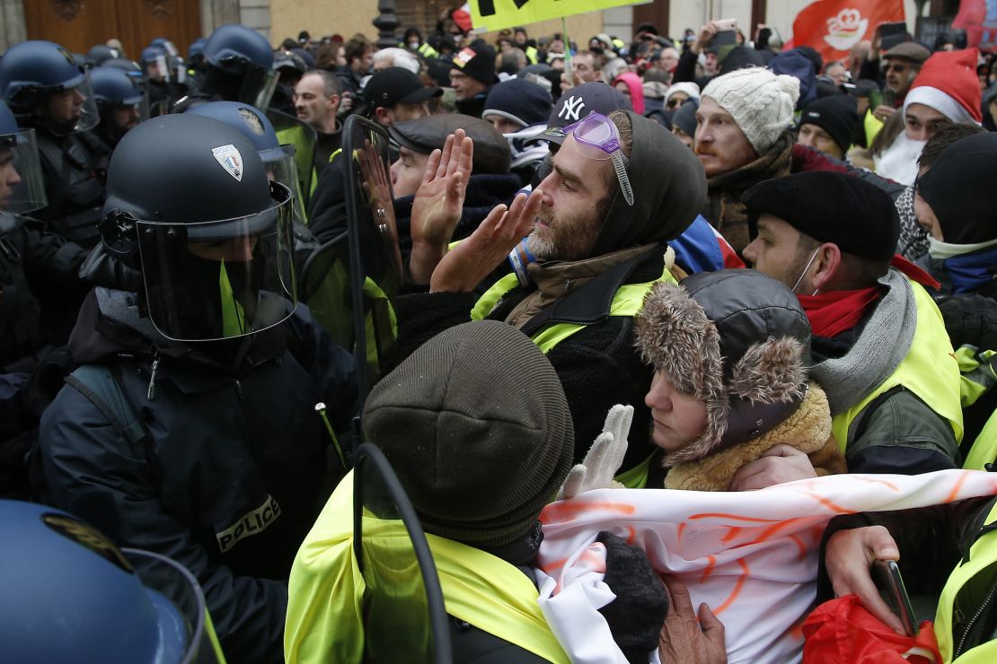 "Yellow vest" demonstrators face riot police officers Saturday in the French capital. 