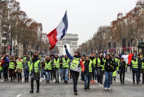 A protester waves the French national flag during a demonstration on the Champs-Élysées in Paris on December 15.