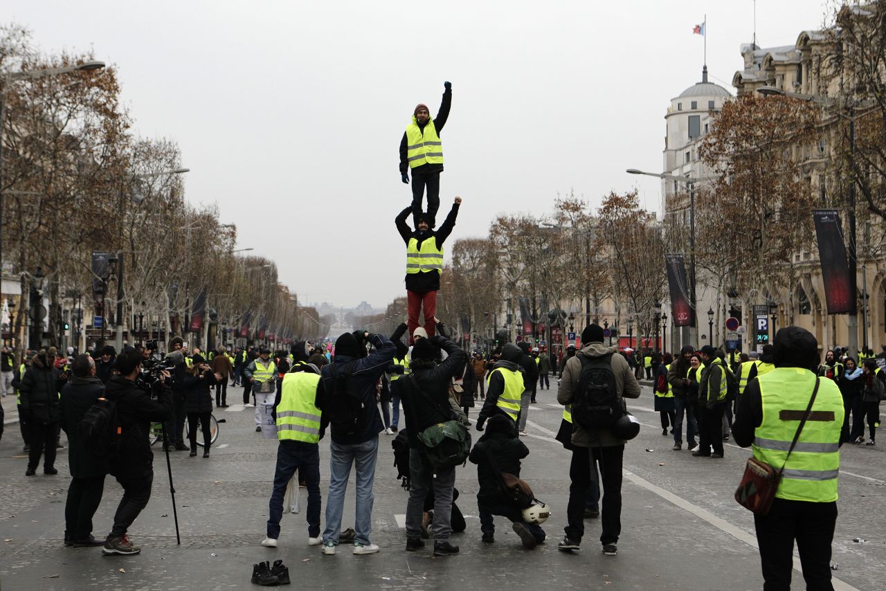 Demonstrators wearing yellow vests form a human tower December 15 on the Champs-Élysées in Paris.