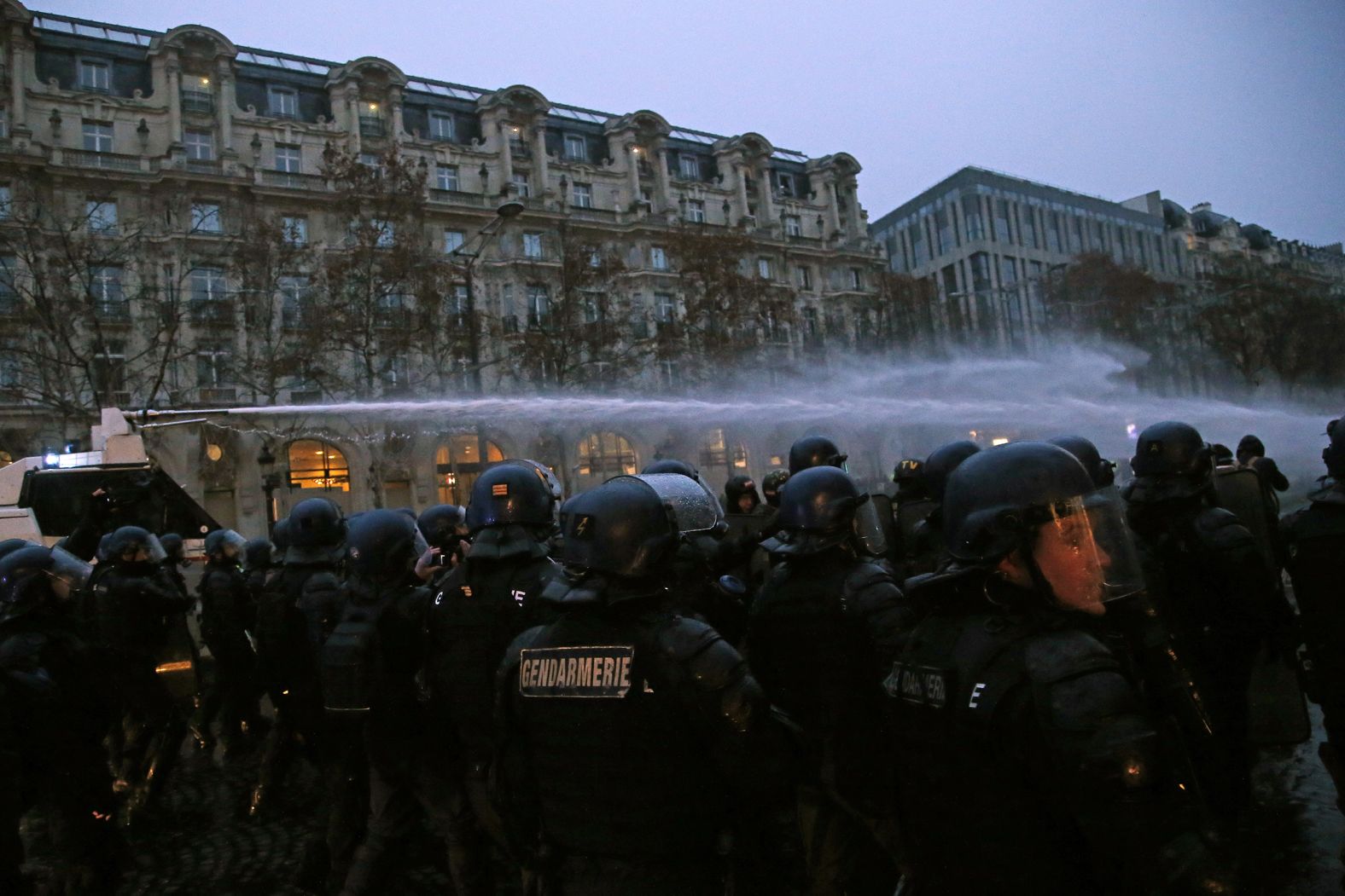 A police water cannon sprays demonstrators on December 15 in Paris.