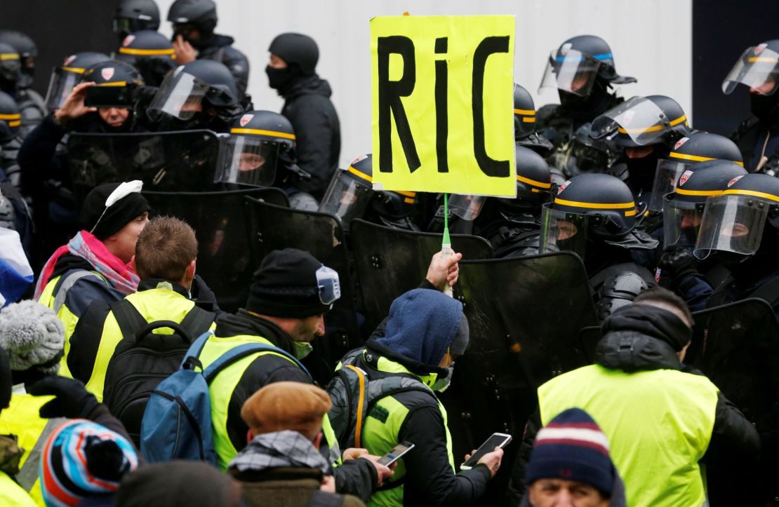 A Paris protester holds a "RIC" sign Saturday in a reference to a demand for a citizens' referendum.