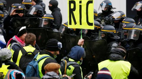 A Paris protester holds a "RIC" sign Saturday in a reference to a demand for a citizens' referendum.