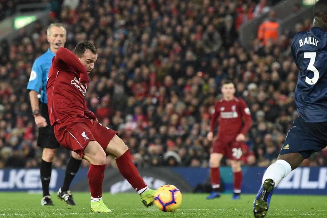 Xherdan Shaqiri shoots to score the third goal for Liverpool against arch-rival Manchester United. 