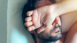 Morning depression and midlife crisis of a man in his 40s lying in bed in morning with symptoms like extreme sadness, frustration, anger and fatigue.  Chronic fatigue syndrome.; Shutterstock ID 680499979; Job: CNNie Design Website