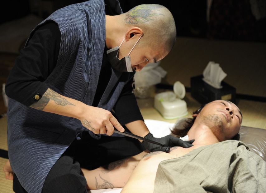 Artist Horimyo tattooing the shoulder of calligrapher Hayato Suzuki in Tokyo.