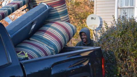 Volunteer Levi Lindsey loads furniture into Guido's pickup truck.