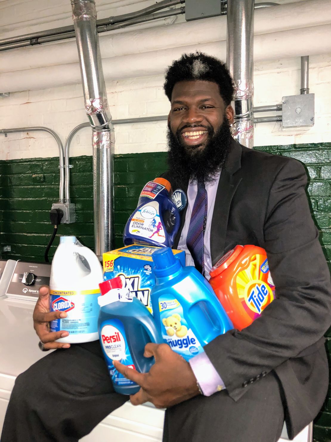 Cook holds an armful of donated laundry products. 