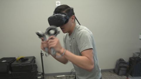San Francisco State Kinesiology graduate student spars with virtual opponent as he tries out VR boxing game. 
