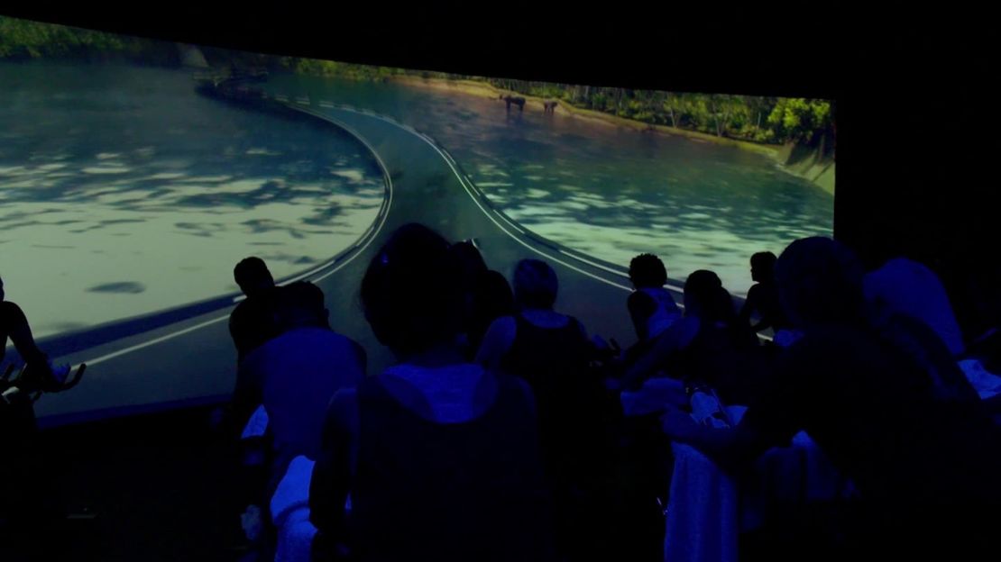 In this spin class, the participants pedal up hills, through forests, over bridges and fantasy lands.