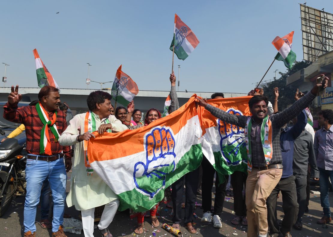 Indian Congress party supporters hold a Congress party flag as they celebrate in Ahmedabad on December 11, 2018 after local elections which saw the ruling BJP suffer major losses.