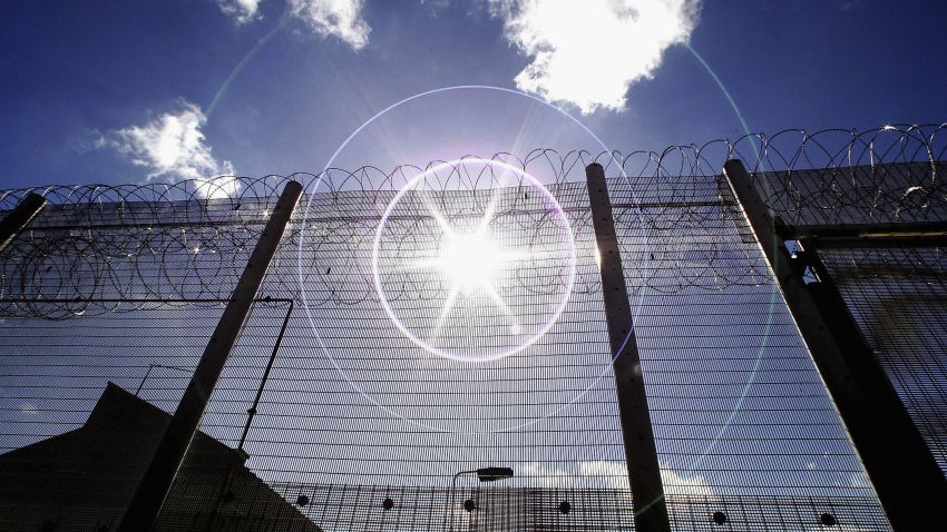 NORWICH, UNITED KINGDOM - AUGUST 25:  (EDITORS NOTE: IMAGES EMBARGOED FOR PUBLICATION UNTIL 0001GMT AUGUST 26, 2005; NATURAL LENS FLARE VISIBLE IN IMAGE) The sun shines through high security fencing surrounding Norwich Prison on August 25, 2005 in Norwich, England. A Chief Inspector of Prisons report on Norwich Prison says healthcare accommodation was among the worst seen, as prisoners suffered from unscreened toilets, little natural light, poor suicide prevention, inadequate education and training for long-term prisoners. (Photo by Peter Macdiarmid/Getty Images)