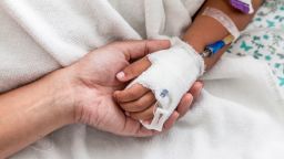 Mother holding child's hand who have IV solution in the hospital; Shutterstock ID 365364938; Job: -