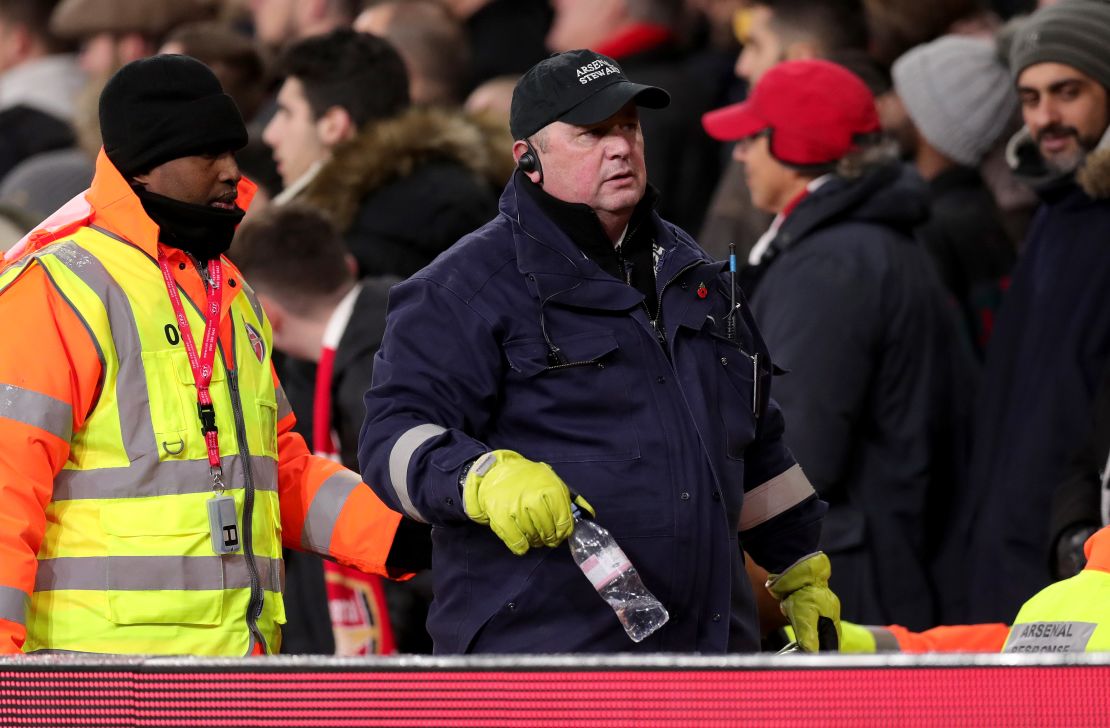 The water bottle which hit Dele Alli of Tottenham Hotspur is removed by a steward.
