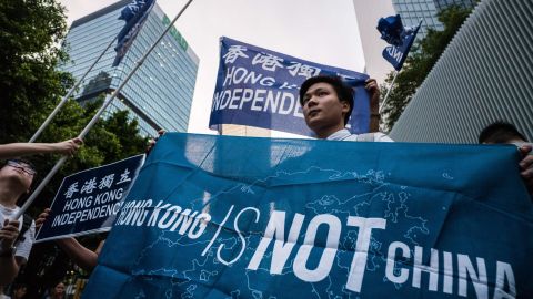 Activists hold flags which read "Hong Kong Independence" and "Hong Kong Is Not China" during a gathering outside the government headquarters to mark the fourth anniversary of mass pro-democracy rallies, known as the Umbrella Movement, in Hong Kong on September 28, 2018.