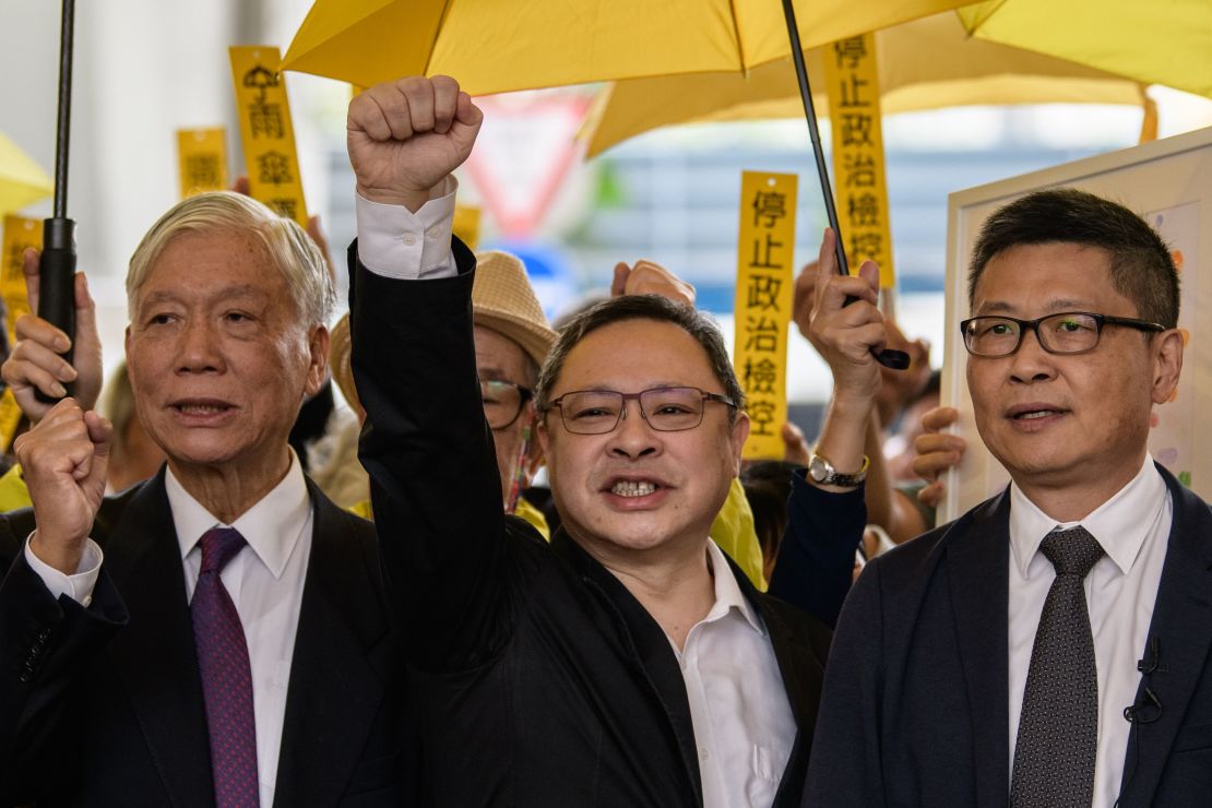 Baptist minister Chu Yiu-ming, 74, law professor Benny Tai, 54, and sociology professor Chan Kin-man, 59, shout slogans with supporters before entering the West Kowloon Magistrates Court in Hong Kong on November 19, 2018.