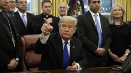 U.S. President Donald Trump takes a question from a member of the media after signing bill H.R. 390, the Iraq and Syria Genocide Relief and Accountability Act of 2018, in the Oval Office of the White House in Washington, D.C., U.S., on Tuesday, Dec. 11, 2018. Trump staged a confrontation Tuesday with the two top congressional Democrats before television cameras in the Oval Office as the dispute over funding for his border wall turned publicly acrimonious. Photographer: Yuri Gripas/Bloomberg via Getty Images