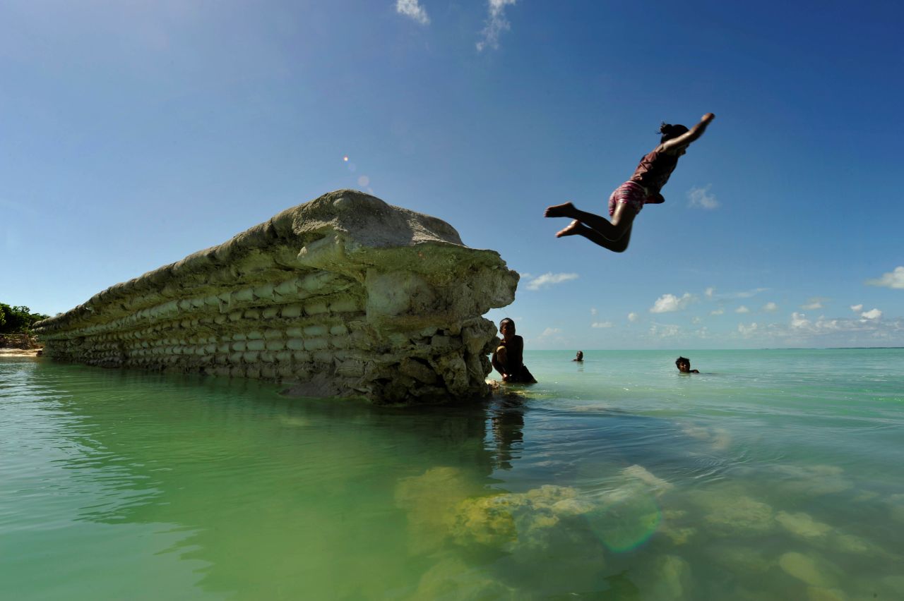 <strong>Kiribati:</strong> A child jumps off a sea wall in the village of Eita, on the island of Tarawa. 