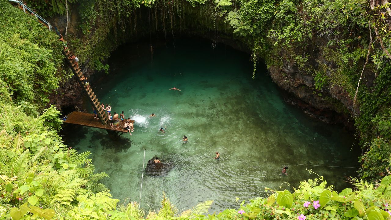 <strong>Samoa:</strong> Visitors swim in the To Sua Ocean Trench in the village of Lotofaga on Upolu island. The trench is a 30-meter-deep (almost 100 feet) hole connected via underground canals to the ocean. Click through the gallery to see more photos of the Samoa and Kiribati island chains and what you can do on vacation there: 
