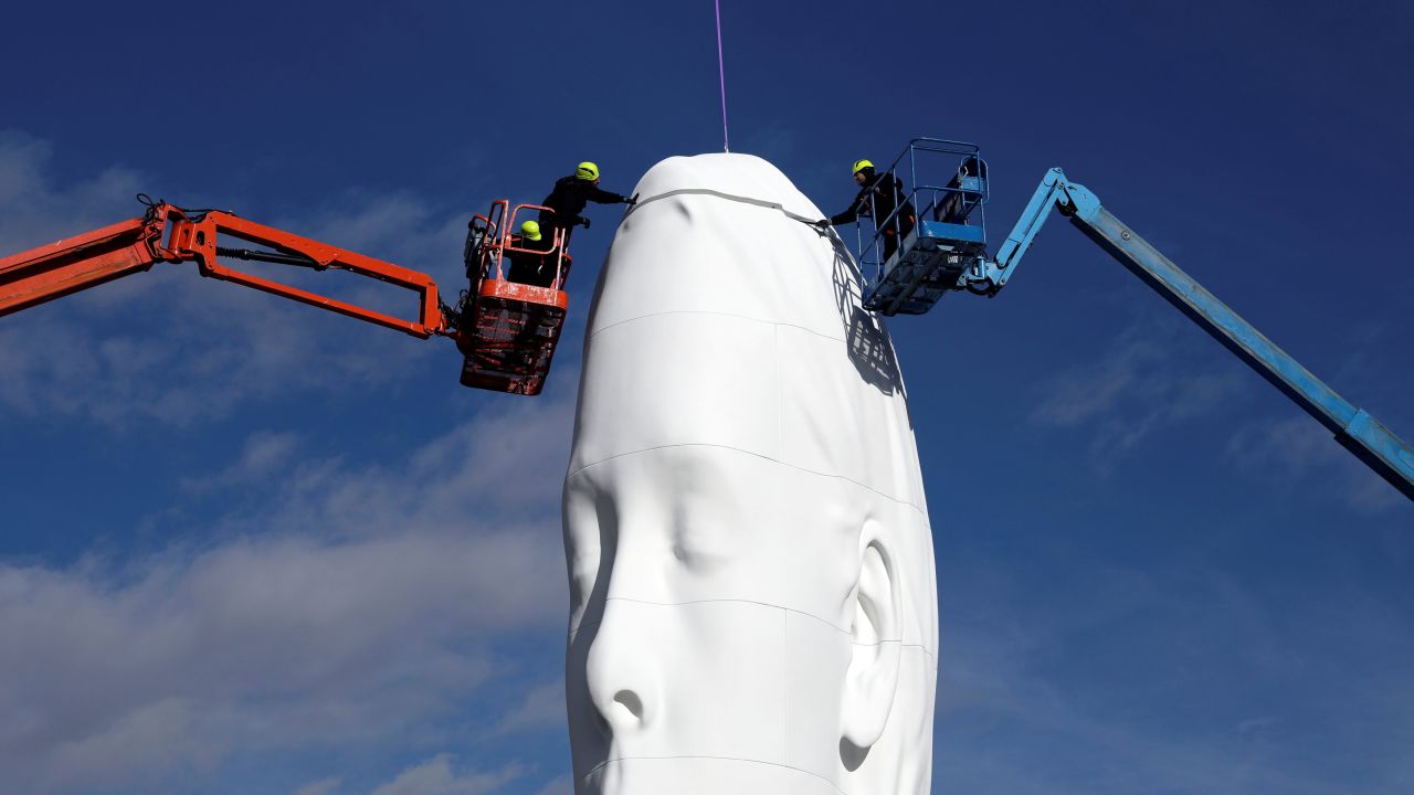 Workers in Madrid put the finishing touches on Jaume Plensa's statue "Julia" on Wednesday, December 19.