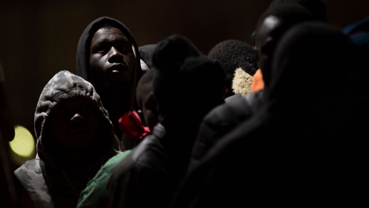 Migrants wait aboard a Spanish Coast Guard boat after arriving in Malaga, Spain, on Tuesday, December 18. The Coast Guard had rescued 104 migrants from an inflatable boat. 