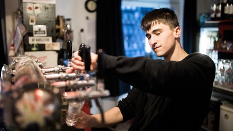 A barman pours a beer at the Aurora.