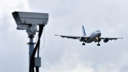 An Air Transat aircraft is pictured beyond a CCTV camera as it prepares to land at London Gatwick Airport, south of London, on December 21, 2018, as flights resumed following the closing of the airfield due to a drones flying. - British police were Friday considering shooting down the drone that has grounded flights and caused chaos at London's Gatwick Airport, with passengers set to face a third day of disruption. Police said it was a "tactical option" after more than 50 sightings of the device near the airfield since Wednesday night when the runway was first closed. (Photo by Ben STANSALL / AFP)        (Photo credit should read BEN STANSALL/AFP/Getty Images)