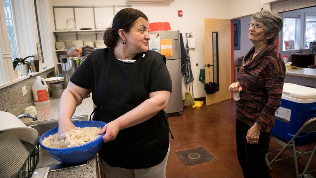 Rosa del Carmen Ortez-Cruz chats with volunteer Libby Johnson as she makes pupusas at Church of Reconciliation in Chapel Hill. The two women have become close friends since Rosa began living at the church in April.