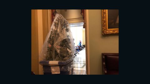 A Christmas tree in a cart is physically removed from Cornyn's office. 