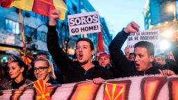 People wave flags and chant slogans while a man carries a protest sign reading "SOROS Go Home" during a demonstration against a deal between Social Democrats and the Albanian Democratic Union for Integration, for a law making Albanian the second official language, on March 15, 2017 in Skopje.
The Macedonian president, who has accused neighbouring Albania of trying to influence political developments across the border, referred to minority ethnic Albanian parties' decision to back opposition chief Zoran Zaev if he accepted their controversial demand to make Albanian an official language across Macedonia.  / AFP PHOTO / Robert ATANASOVSKI        (Photo credit should read ROBERT ATANASOVSKI/AFP/Getty Images)