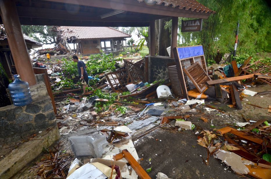 A man walks amid debris from damaged buildings in Carita, Indonesia.