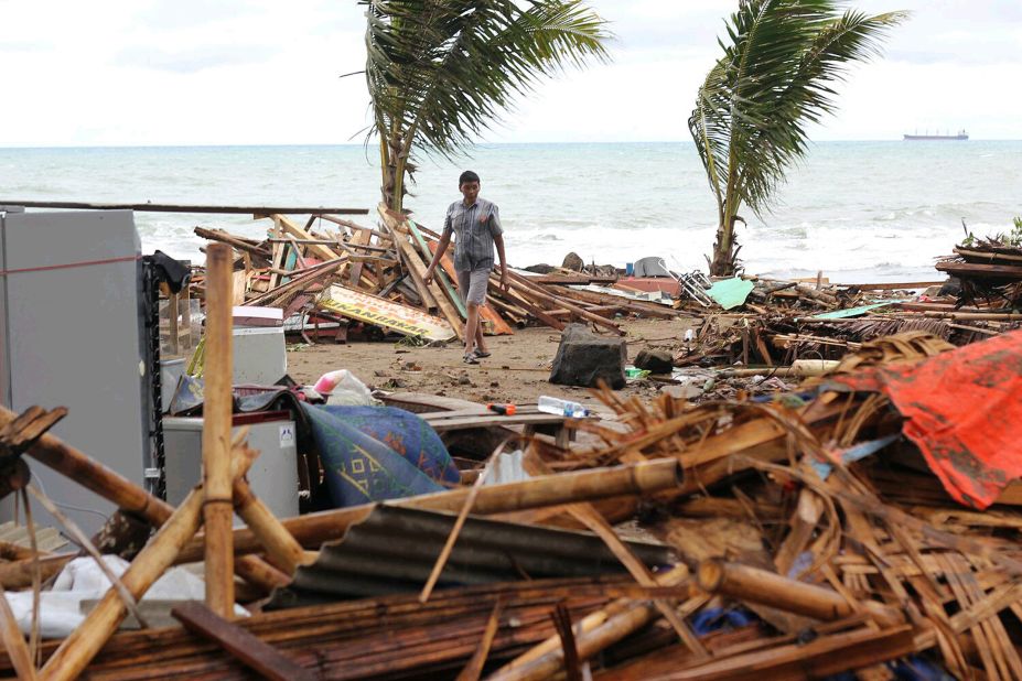 A resident walks past buildings damaged by a tsunami in Carita, Indonesia, on Sunday.