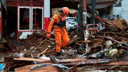 A rescue worker walks through the rubble from houses destroyed by a tsunami on December 23, 2018 in Carita, Indonesia. 