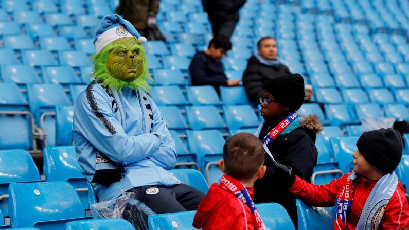 Children approach a Manchester City fan wearing a Grinch mask before a Premier League soccer match between Manchester City and Crystal Palace on December 22 in Manchester, England.