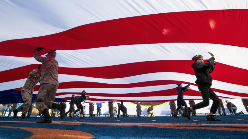Volunteers help wave a giant US flag presented at the start of the Famous Idaho Potato Bowl on Friday, December 21 at Albertsons Stadium in Boise. Brigham Young defeated Western Michigan 49-18.