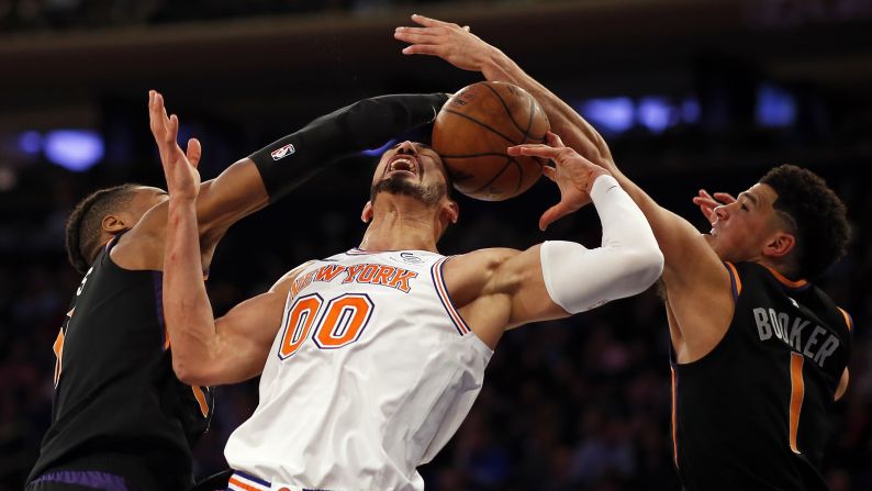 New York Knicks center Enes Kanter is hit with the ball as he battles for a rebound between Phoenix Suns guards Devin Booker and Jamal Crawford  during the second half of their game at Madison Square Garden in New York City on December 17.