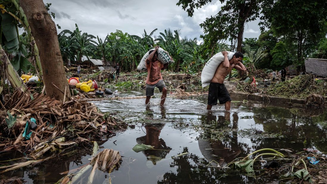 Villagers walk through debris in Carita, Banten province, Indonesia, on Monday following the tsunami.