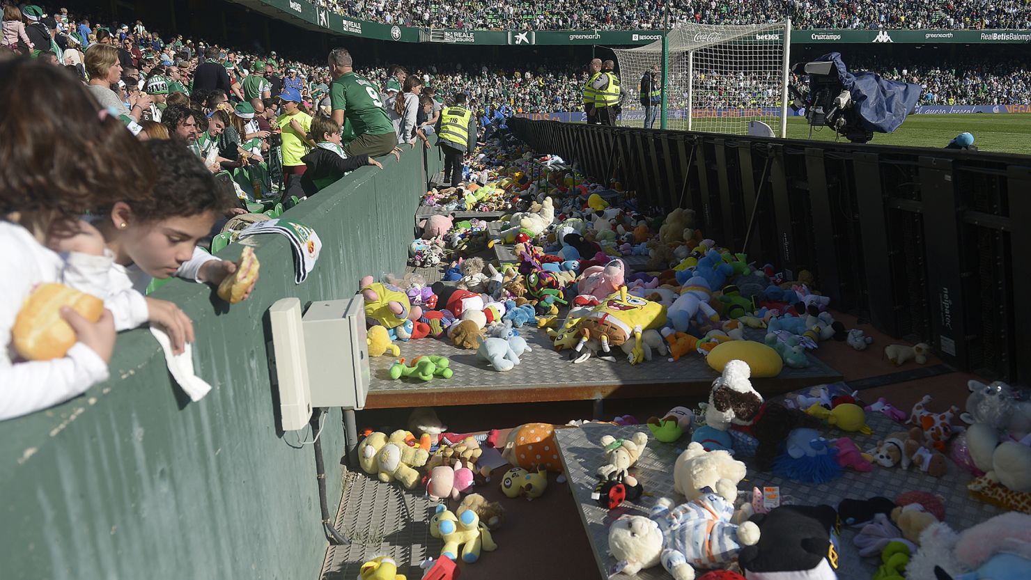 Real Betis fans throw stuffed animals to be collected and given to children in need.