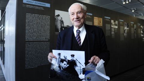 Bach holds a photo as he tours the 2011 exhibit "Facing Justice -- Adolf Eichmann on Trial" in Berlin. 