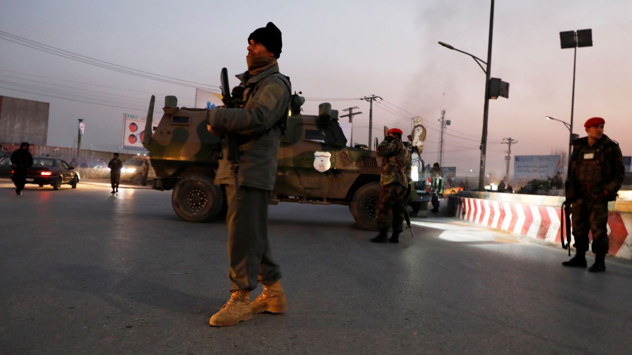 Afghan security forces stand guard at the site of the attack in Kabul.
