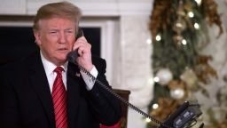 US President Donald Trump speaks on the telephone as he answers calls from people calling into the NORAD Santa tracker phone line in the State Dining Room of the White House in Washington, DC, on December 24, 2018. (Photo by SAUL LOEB / AFP)SAUL LOEB/AFP/Getty Images