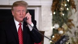 US President Donald Trump speaks on the telephone as he answers calls from people calling into the NORAD Santa tracker phone line in the State Dining Room of the White House in Washington, DC, on December 24, 2018. (Photo by SAUL LOEB / AFP)        (Photo credit should read SAUL LOEB/AFP/Getty Images)