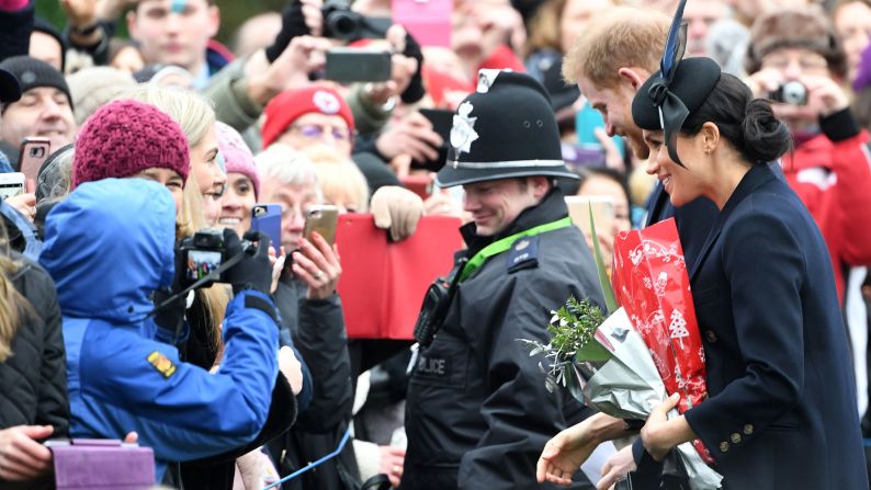 Meghan, Duchess of Sussex and Britain's Prince Harry, Duke of Sussex greet the crowds as they depart after the royal family's traditional Christmas Day service at St. Mary Magdalene Church. 