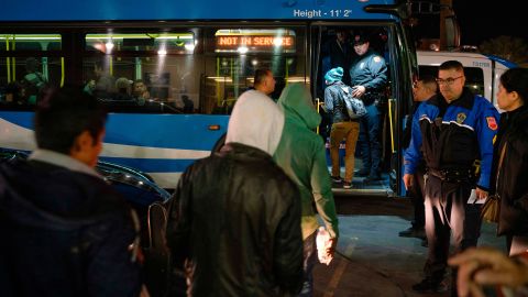 Migrants board buses Sunday night in El Paso after ICE officials dropped them off earlier.